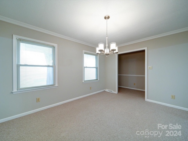 empty room featuring light colored carpet, a chandelier, and ornamental molding