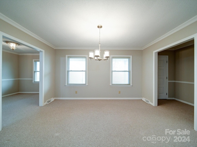 carpeted spare room with a chandelier, a textured ceiling, and ornamental molding