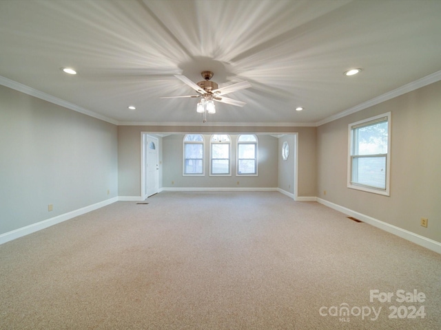 carpeted empty room featuring ceiling fan and crown molding