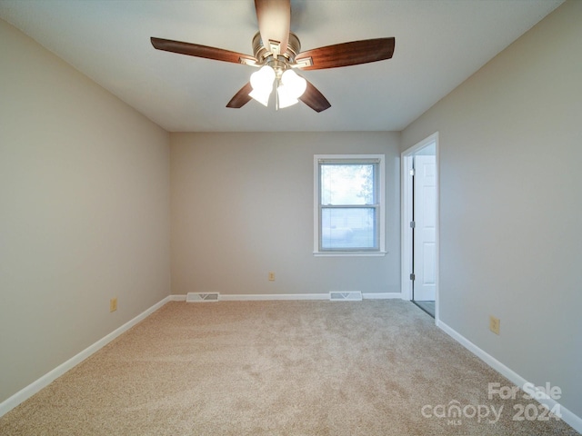 carpeted spare room featuring ceiling fan