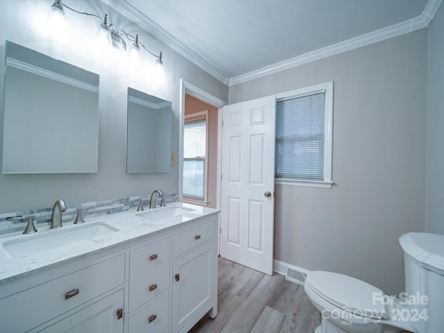 bathroom with toilet, wood-type flooring, crown molding, and vanity