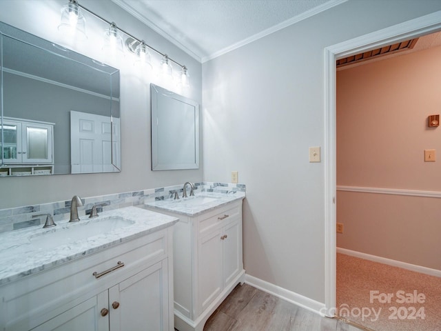 bathroom with wood-type flooring, crown molding, and vanity