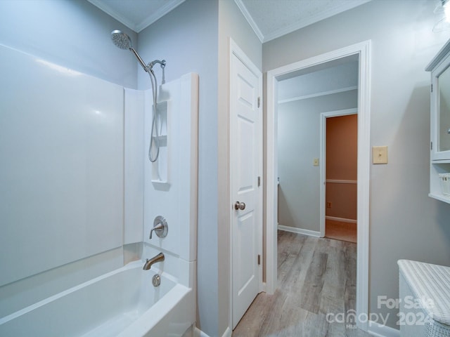 bathroom featuring hardwood / wood-style flooring, washtub / shower combination, and ornamental molding