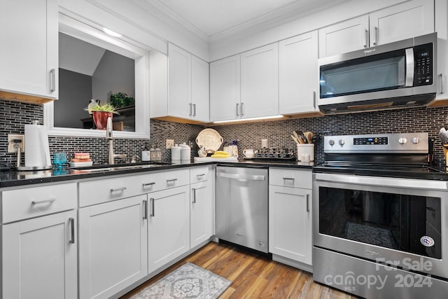 kitchen with white cabinets, decorative backsplash, and appliances with stainless steel finishes