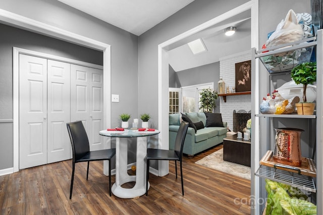 dining room featuring a skylight and dark hardwood / wood-style flooring