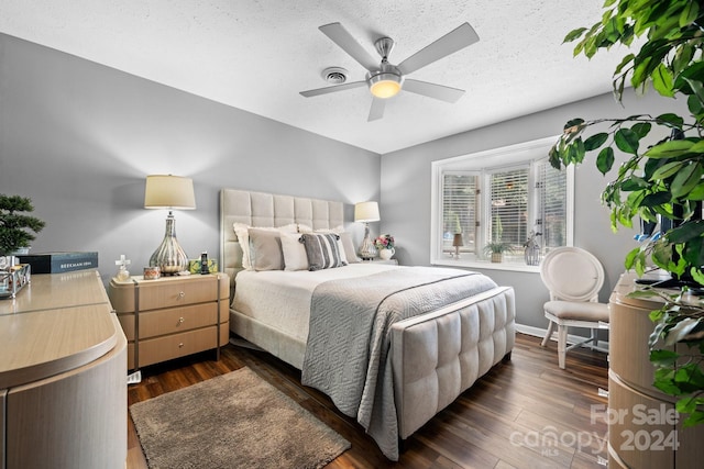 bedroom with dark wood-type flooring, a textured ceiling, and ceiling fan