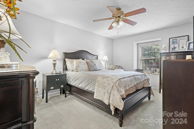 carpeted bedroom featuring a textured ceiling and ceiling fan