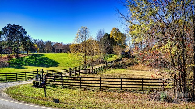 view of gate with a yard and a rural view