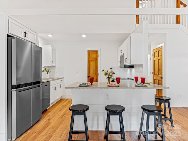 kitchen with a breakfast bar, light wood-style flooring, and stainless steel appliances