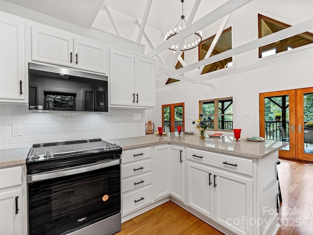 kitchen featuring a peninsula, stainless steel electric stove, french doors, light wood-type flooring, and white cabinetry