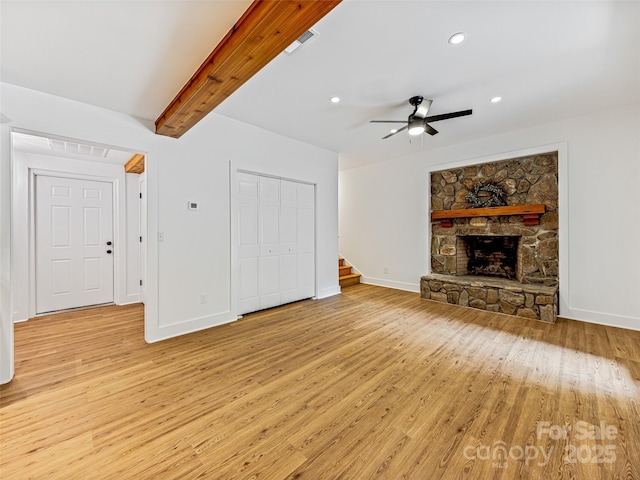 unfurnished living room featuring light wood-type flooring, stairway, a fireplace, and visible vents