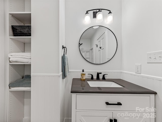 bathroom with a wainscoted wall and vanity