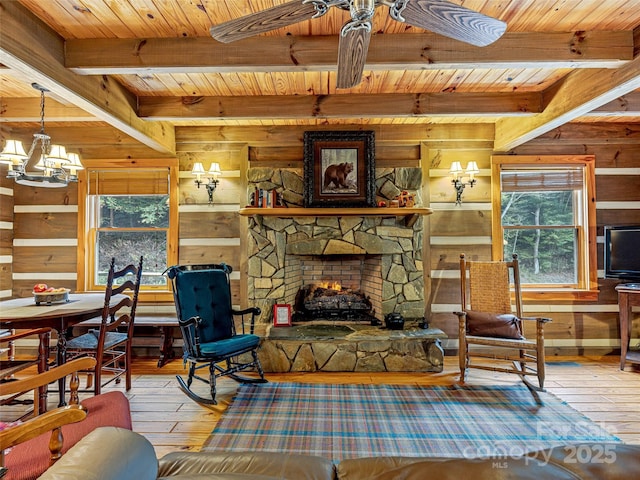 living area with a healthy amount of sunlight, wood walls, and a stone fireplace