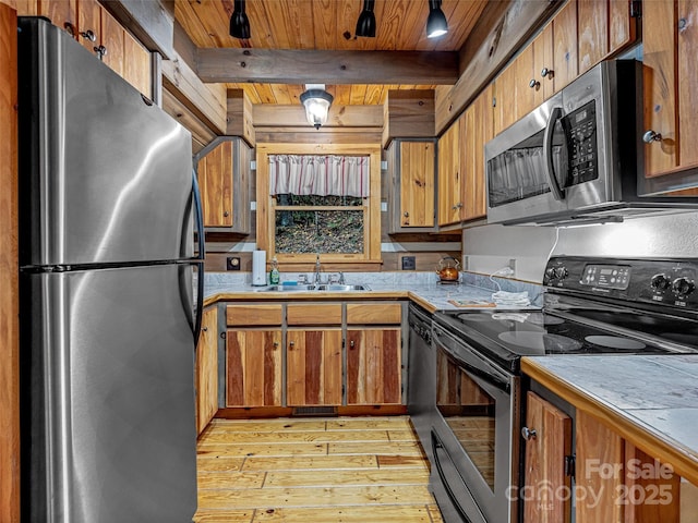 kitchen featuring brown cabinets, stainless steel appliances, and a sink