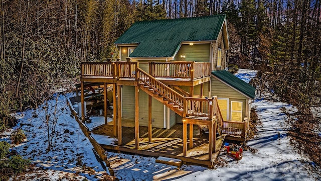 snow covered playground featuring a wooden deck