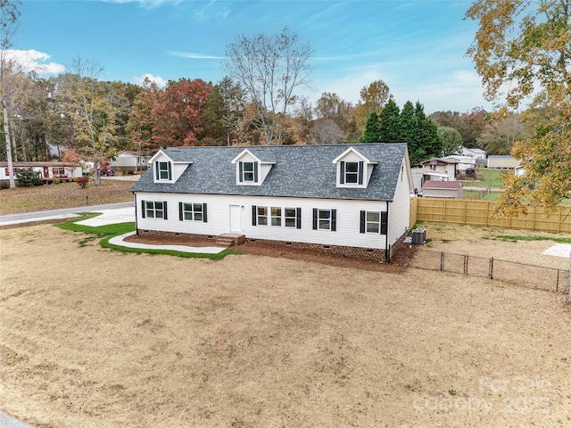 cape cod house featuring cooling unit and a front lawn