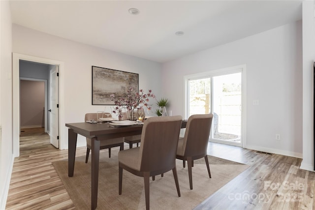 dining space with light hardwood / wood-style flooring