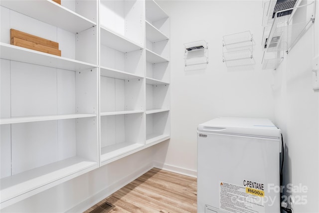 spacious closet featuring light hardwood / wood-style floors