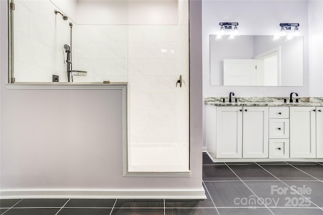 bathroom featuring tile patterned flooring, vanity, and a tile shower