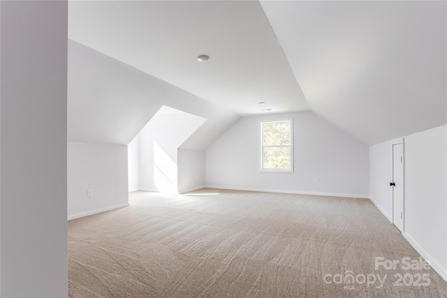 bonus room featuring vaulted ceiling and light colored carpet