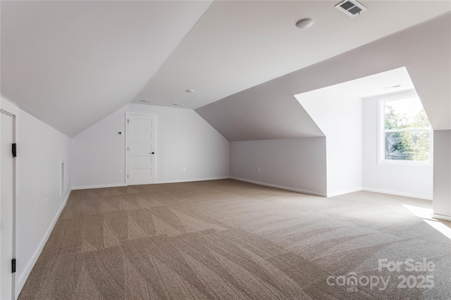 additional living space featuring vaulted ceiling and carpet floors