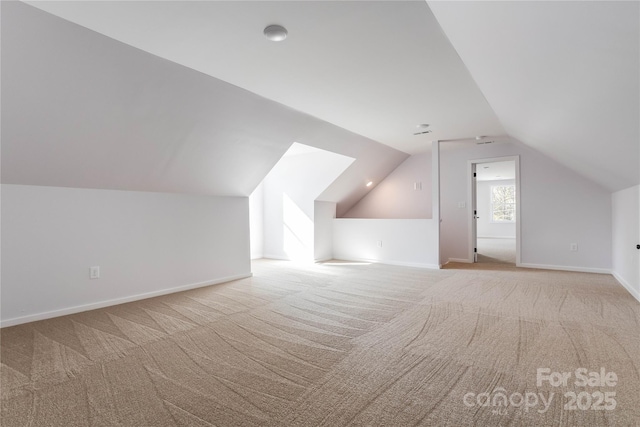 additional living space with vaulted ceiling and light colored carpet