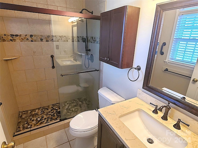 bathroom with walk in shower, toilet, vanity, and tile patterned floors