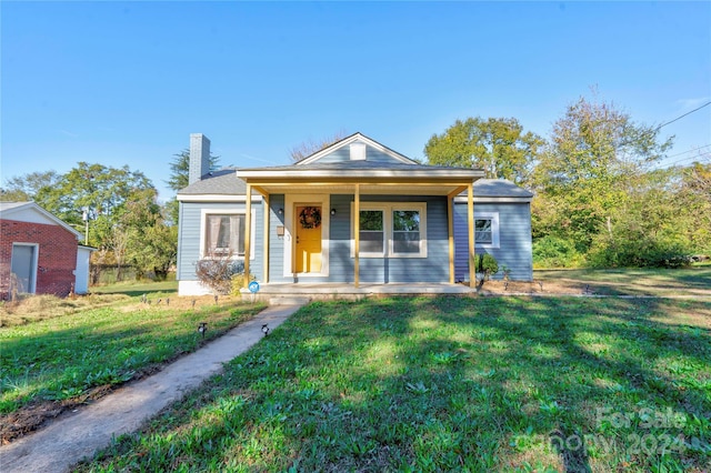 bungalow-style home with covered porch and a front yard