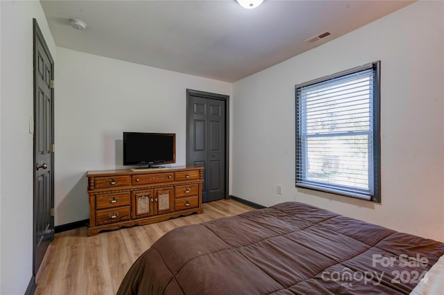 bedroom with light hardwood / wood-style flooring and a closet