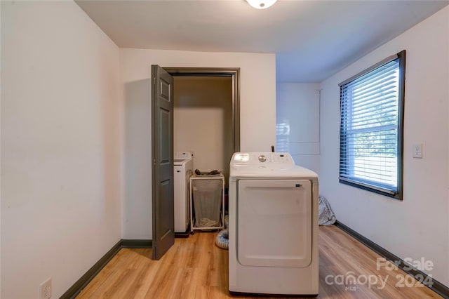 clothes washing area featuring light wood-type flooring and washer and dryer