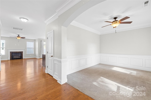 spare room featuring hardwood / wood-style flooring, a premium fireplace, and crown molding