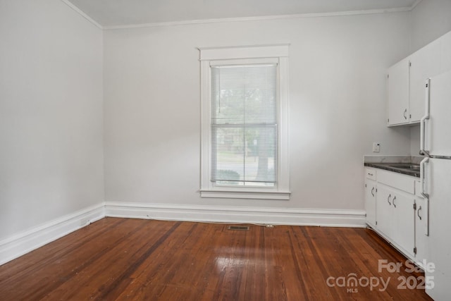 unfurnished dining area featuring crown molding and dark hardwood / wood-style floors