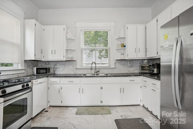 kitchen featuring appliances with stainless steel finishes, sink, white cabinets, backsplash, and ornamental molding