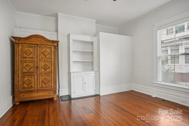 interior space with dark wood-type flooring and ornamental molding