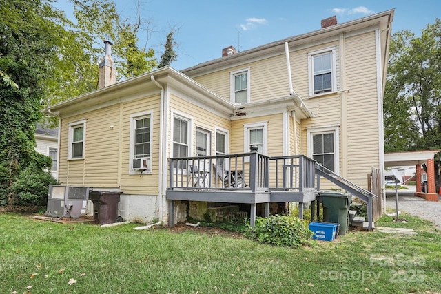 back of house featuring a wooden deck, central AC unit, and a lawn