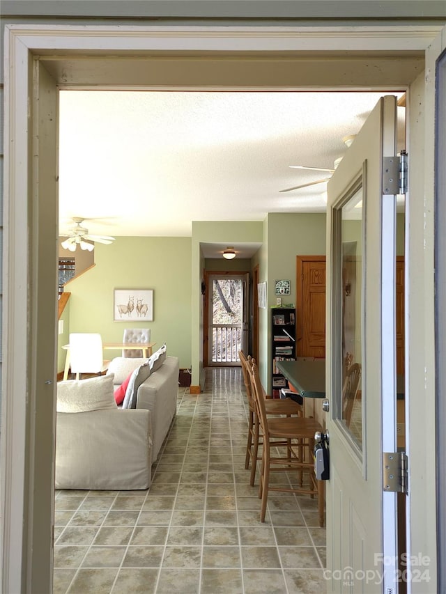 living room featuring ceiling fan and light tile patterned floors