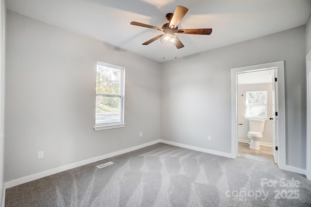 unfurnished bedroom with connected bathroom, light carpet, and ceiling fan