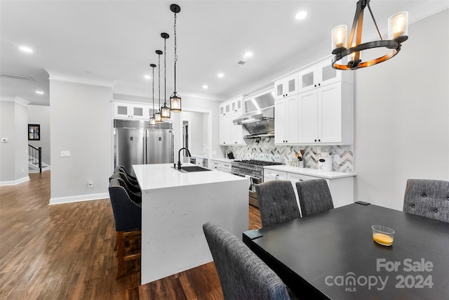 kitchen featuring white cabinets, premium appliances, wall chimney range hood, and sink