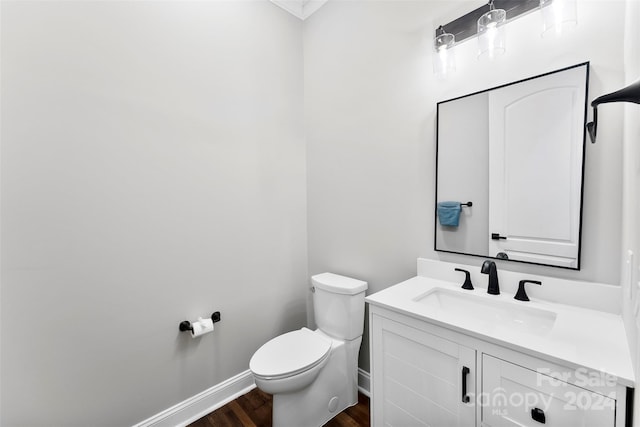 bathroom featuring wood-type flooring, vanity, and toilet