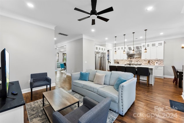 living room featuring dark hardwood / wood-style flooring, ceiling fan, and crown molding