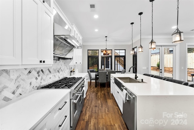 kitchen featuring a center island with sink, decorative light fixtures, sink, and stainless steel appliances