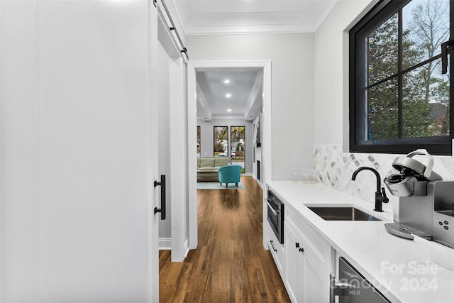 bar featuring dark hardwood / wood-style flooring, sink, white cabinets, and plenty of natural light