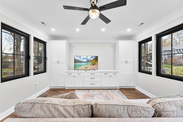 living room featuring dark hardwood / wood-style flooring, crown molding, and a healthy amount of sunlight