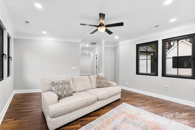 living room with crown molding, ceiling fan, and dark wood-type flooring