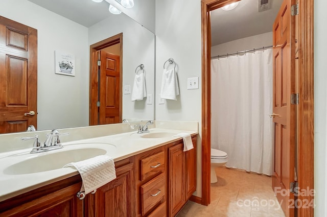 bathroom featuring tile patterned flooring, vanity, and toilet