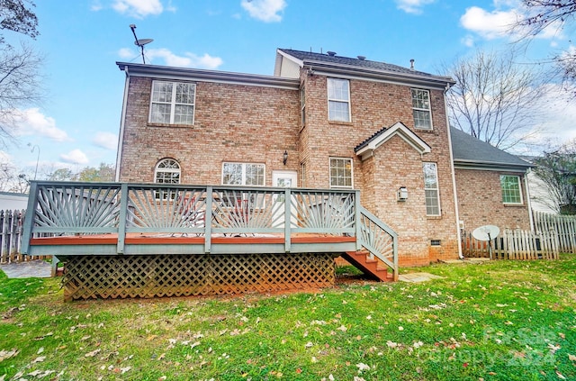 back of property with a deck and a lawn