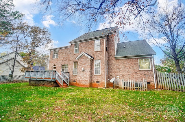 rear view of property featuring a yard and a deck