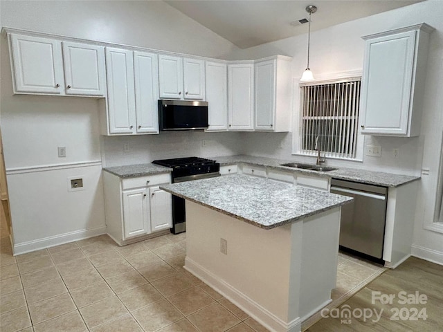 kitchen featuring stainless steel appliances, white cabinetry, pendant lighting, sink, and lofted ceiling