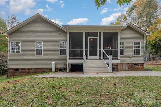 rear view of property with a patio, a sunroom, and a yard