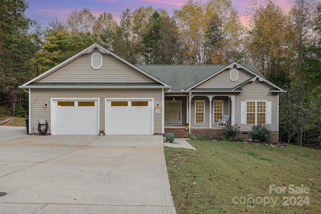 ranch-style house featuring a lawn and a garage